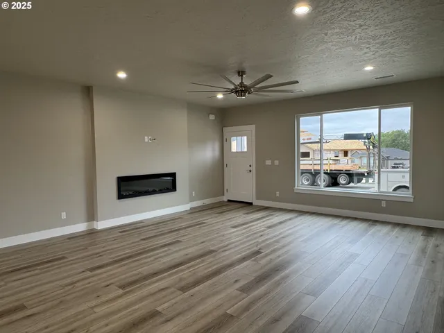 an empty room with wooden floor and a fireplace