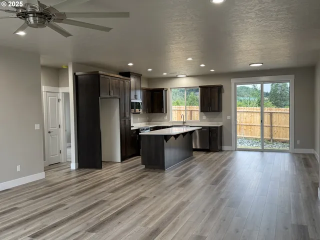an open kitchen with a refrigerator and a stove top oven