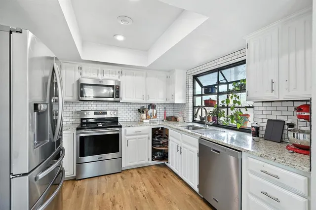 a kitchen with stainless steel appliances granite countertop a refrigerator dining table and chairs