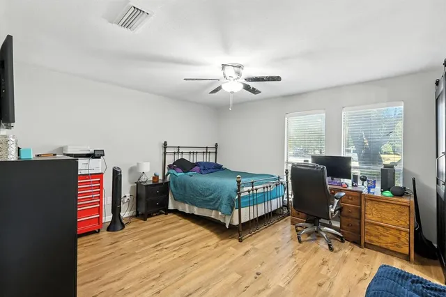 a bedroom with a bed and wooden floor