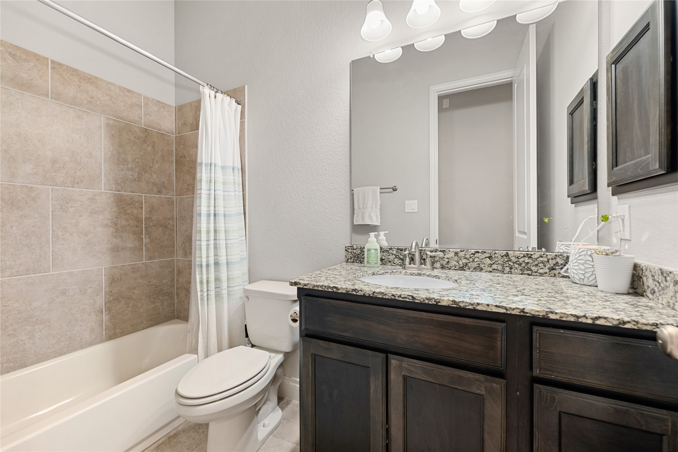 4103 August Light Court Fulshear, TX 77441 - Photo 23 of 33 a bathroom with a granite countertop sink toilet mirror and shower
