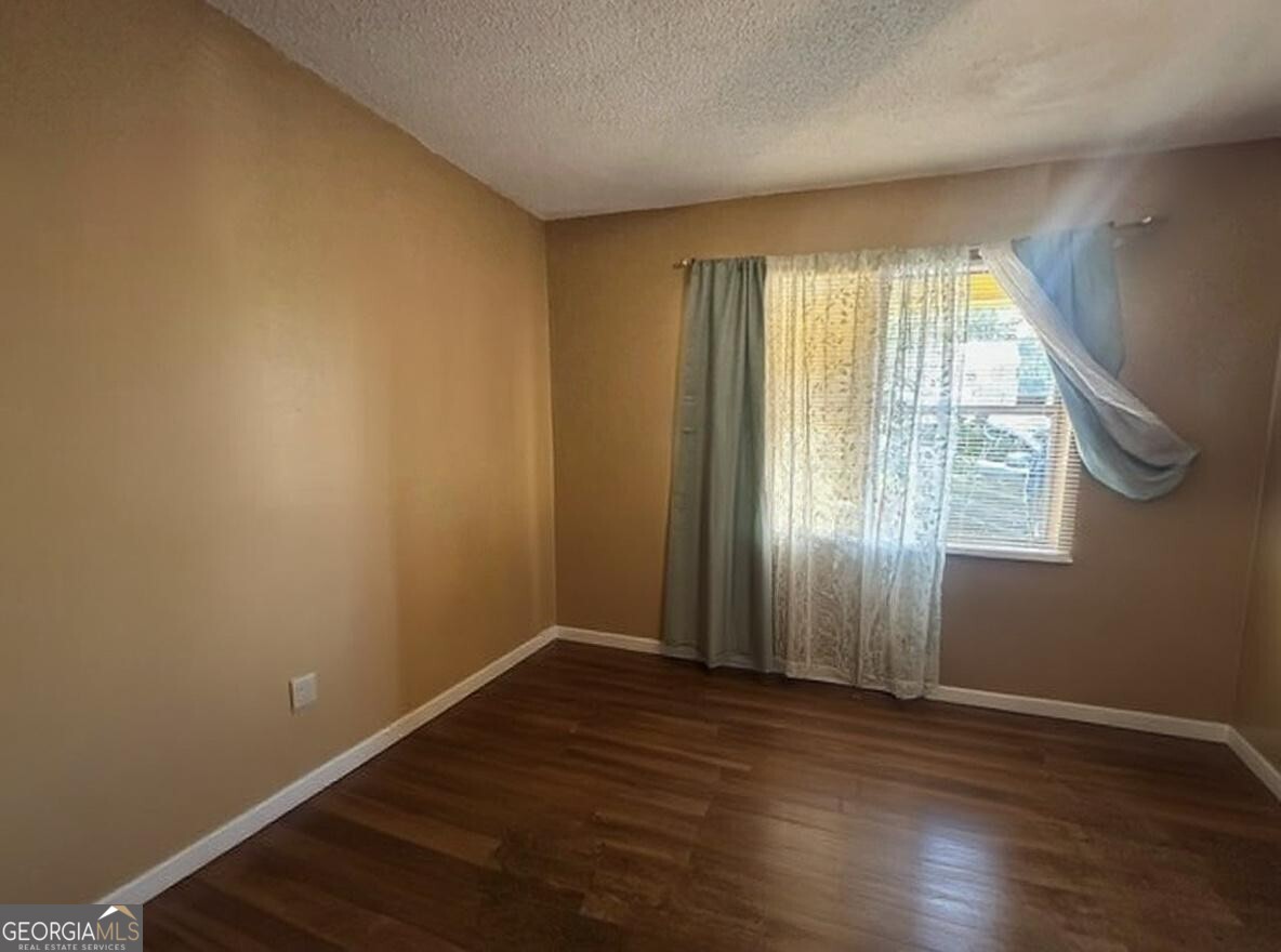 103 Floyd Street Statesboro, GA 30458 - Photo 3 of 22 an empty room with wooden floor and windows
