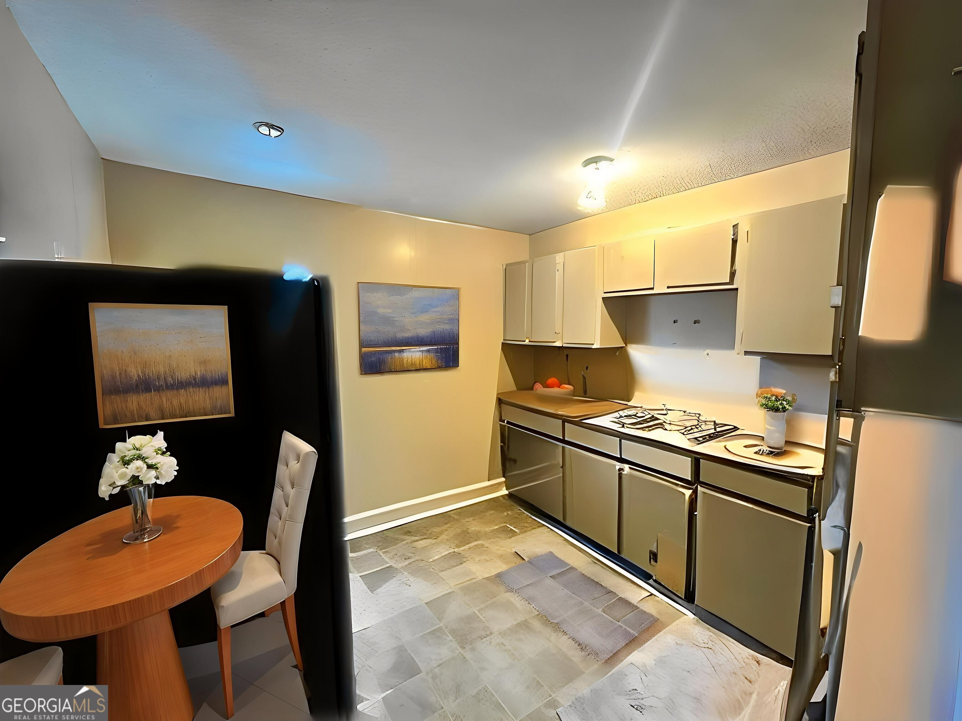 103 Floyd Street Statesboro, GA 30458 - Photo 4 of 22 a kitchen with stainless steel appliances granite countertop a stove a refrigerator a sink a dining table and chairs with wooden floor