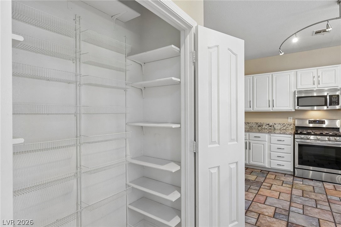 1727 Millstream Way Henderson, NV 89074 - Photo 21 of 46 Well-appointed pantry with ample shelving stands ready to organize kitchen essentials.