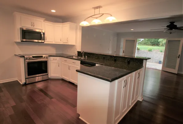 a kitchen with granite countertop a sink and a stove top oven