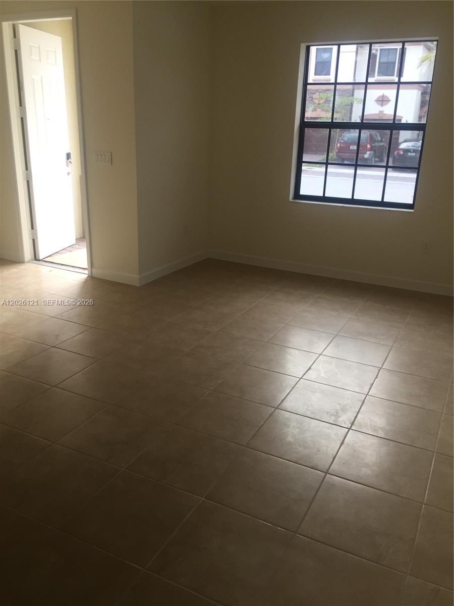 9307 West 33rd Way Hialeah, FL 33018 - Photo 3 of 23 an empty room with windows and entrance