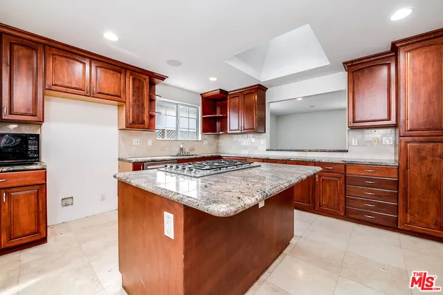 a kitchen with stainless steel appliances granite countertop a stove top oven a sink and dishwasher