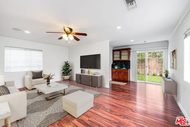 a view of a room with wooden floor and a ceiling fan