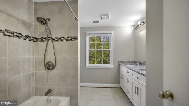 a bathroom with a granite countertop sink and a window