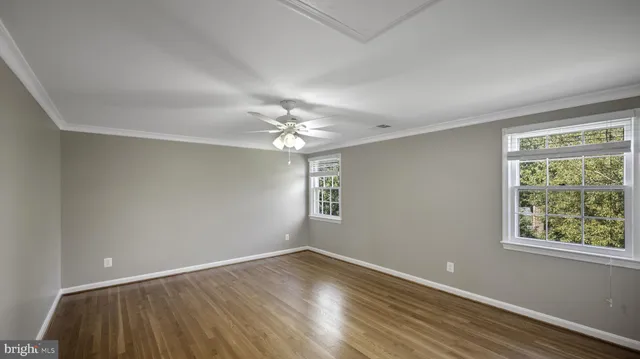 a view of an empty room with wooden floor and a cabinet