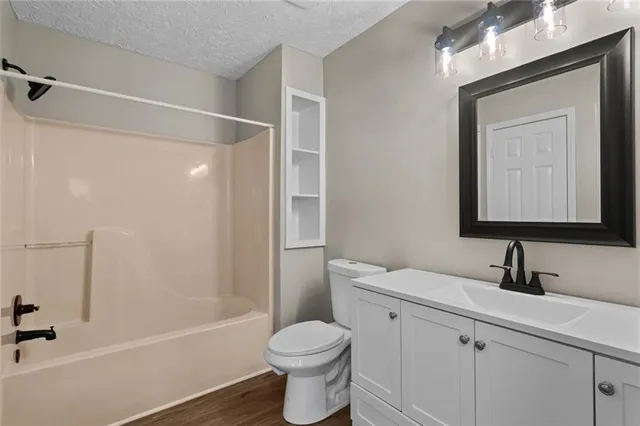 a bathroom with a toilet sink vanity tub and shower