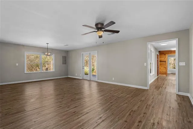 a view of an empty room with window and wooden floor