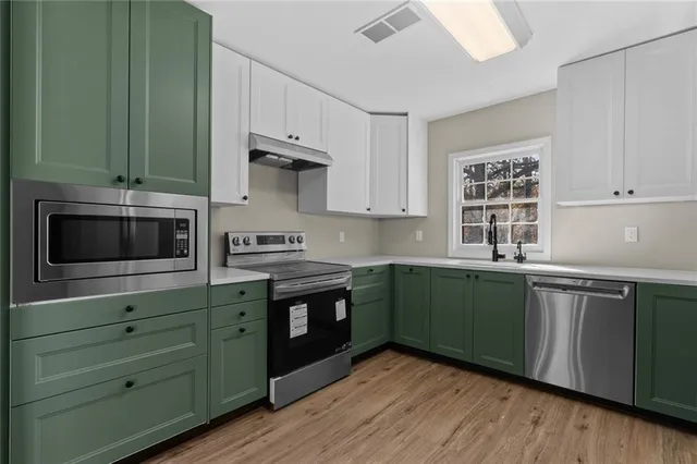 a kitchen with granite countertop cabinets stainless steel appliances and a sink