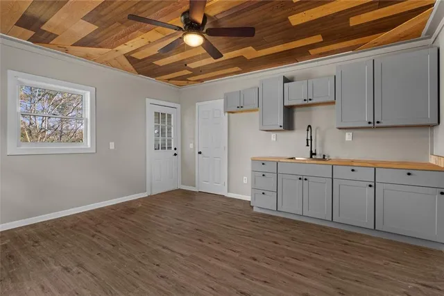 a kitchen with cabinets wooden floor and a sink
