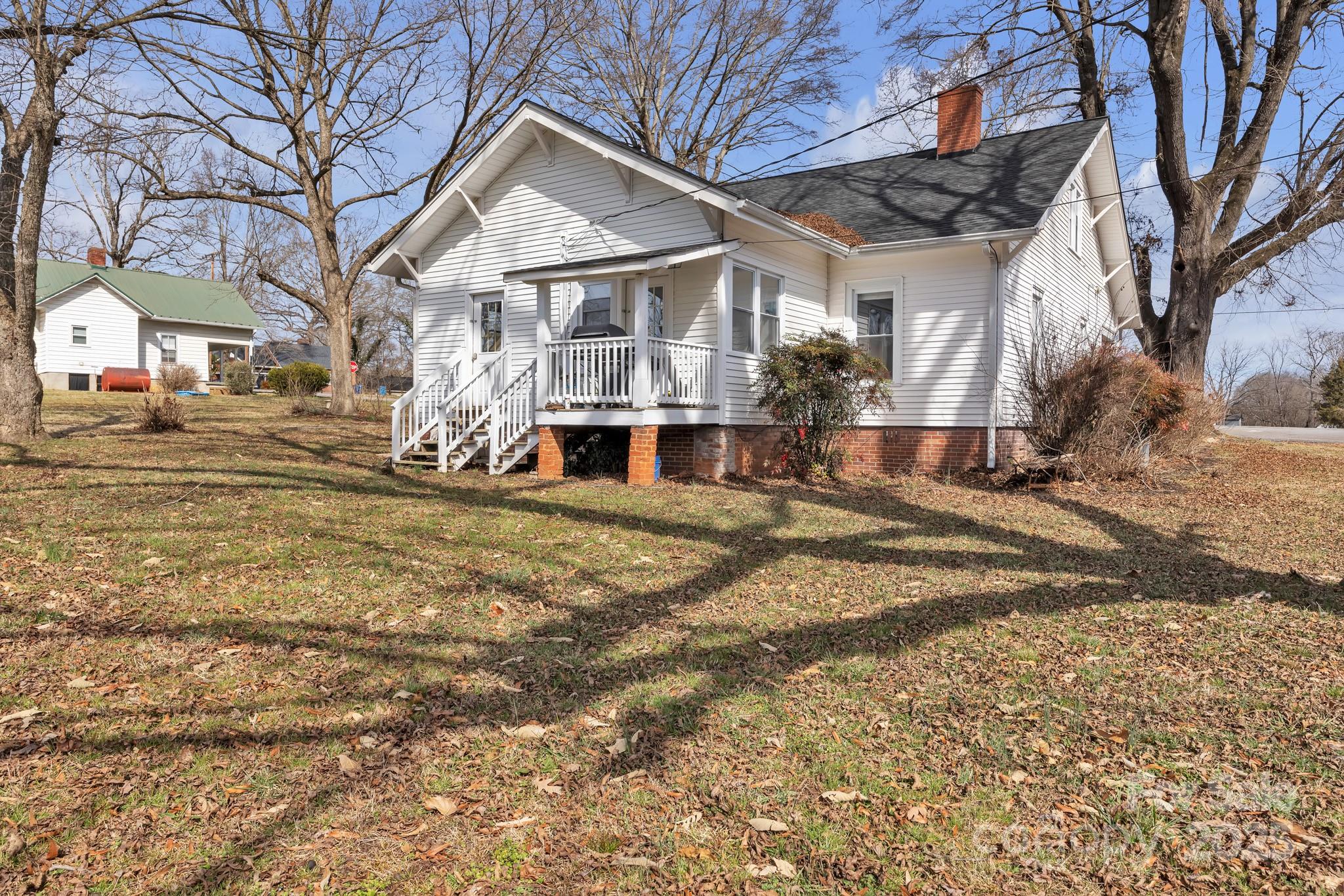 34 Lee Road Stony Point, NC 28678 - Photo 19 of 22 a view of a white house with a yard covered in snow