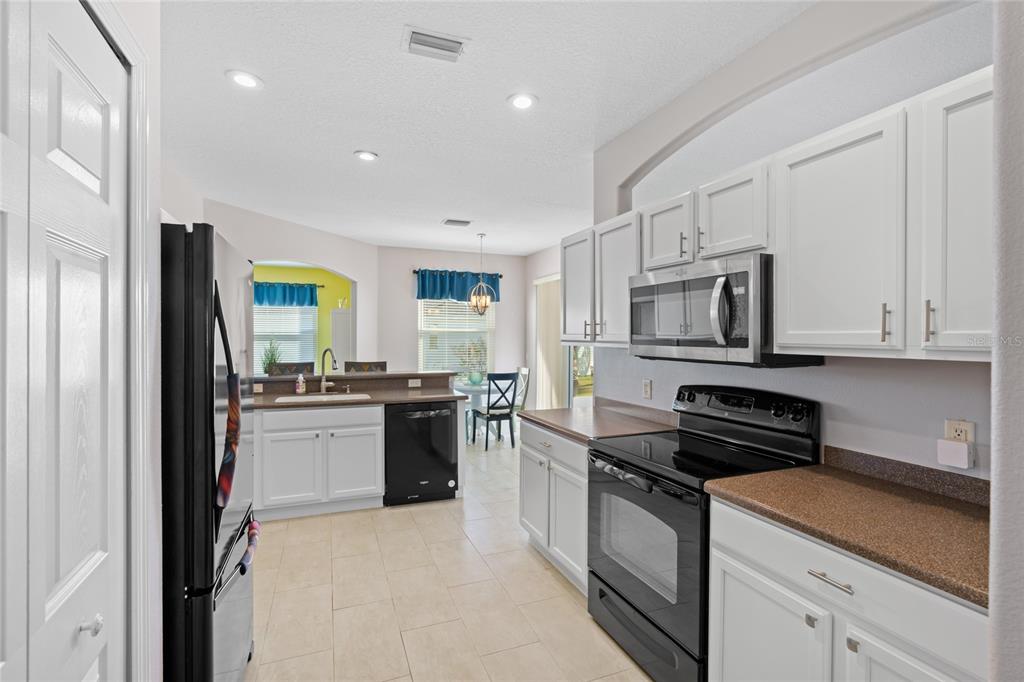 15657 Southwest 11th Terrace Road Ocala, FL 34473 - Photo 12 of 42 a kitchen with stainless steel appliances granite countertop a stove a sink and a refrigerator
