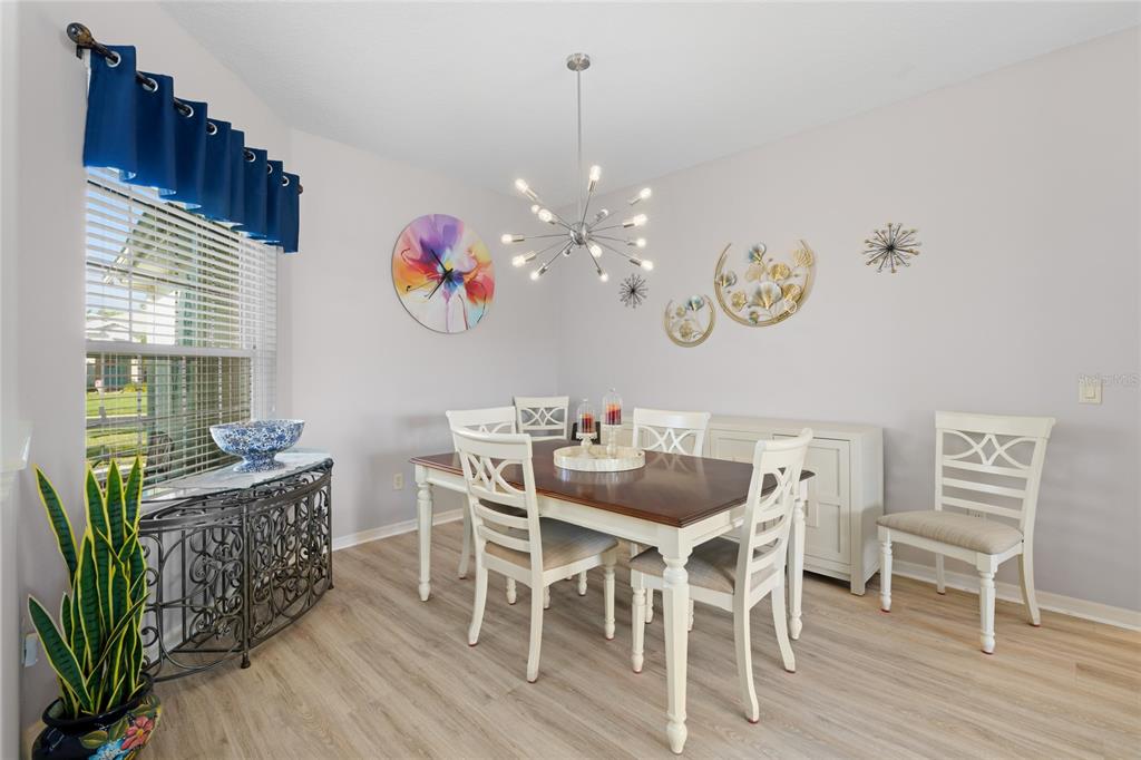 15657 Southwest 11th Terrace Road Ocala, FL 34473 - Photo 7 of 42 a dining room with furniture a chandelier and wooden floor