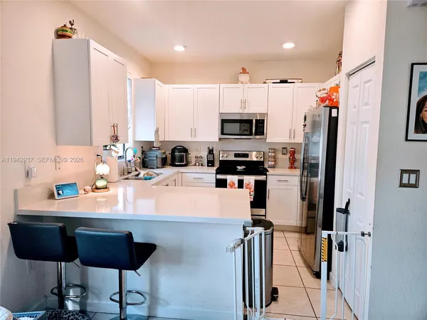 a kitchen with stainless steel appliances a refrigerator sink and cabinets