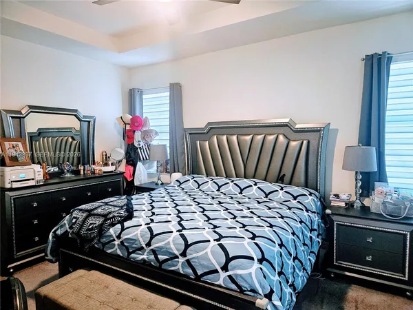 a bed sitting in a bedroom next to a window with dresser