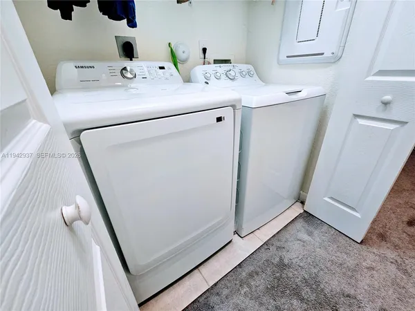 a utility room with cabinets washer and dryer