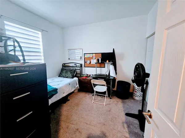 a bedroom with bed and a window