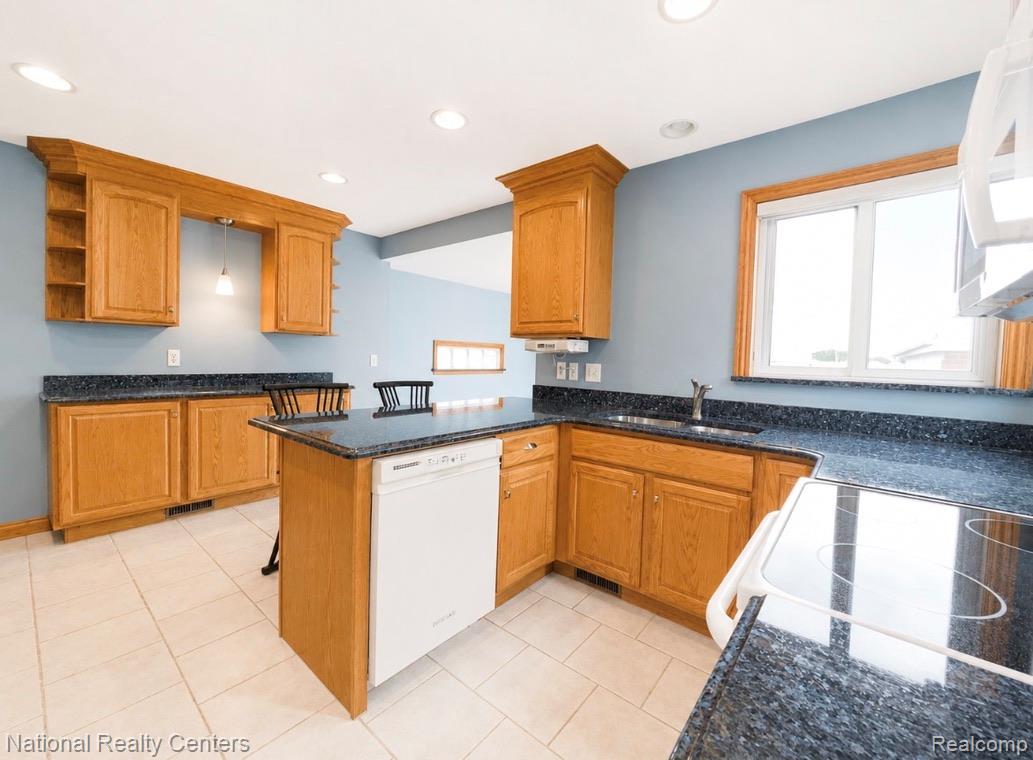 7285 Helen Street Center Line, MI 48015 - Photo 10 of 32 Kitchen featuring light wood cabinetry, dark speckled countertops, and light tile flooring