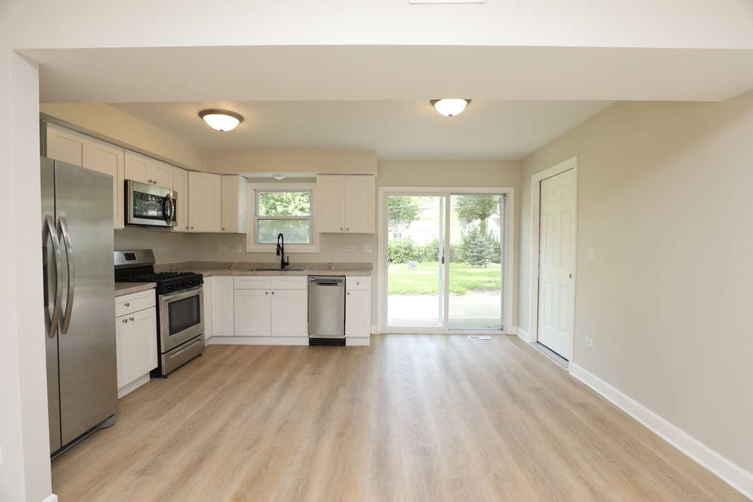 544 Spruce Road Bolingbrook, IL 60440 - Photo 3 of 13 a kitchen with a white cabinets and wooden floor