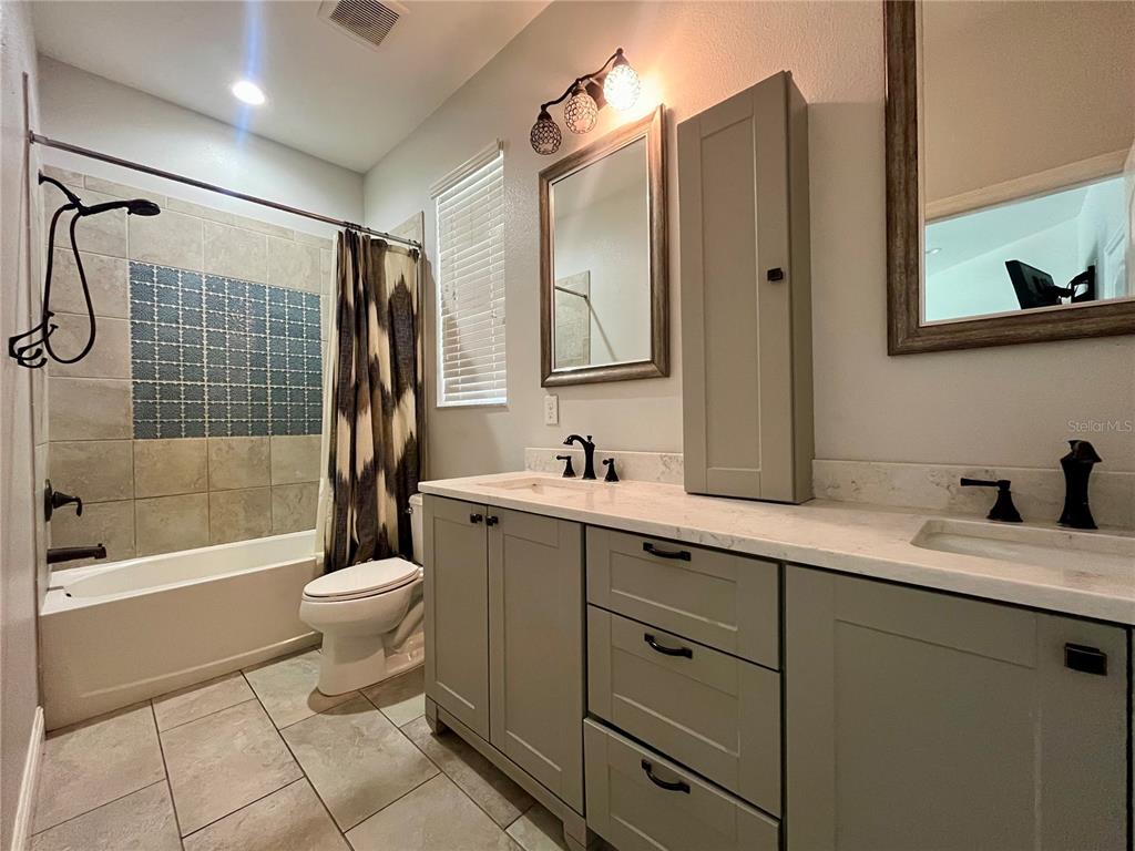 6328 Barton Road Plant City, FL 33565 - Photo 19 of 28 a bathroom with a granite countertop sink toilet mirror and shower