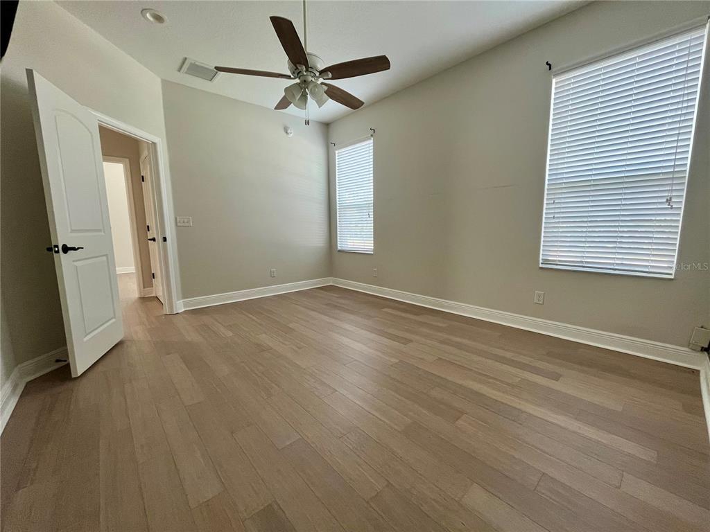 6328 Barton Road Plant City, FL 33565 - Photo 25 of 28 an empty room with wooden floor fan and windows