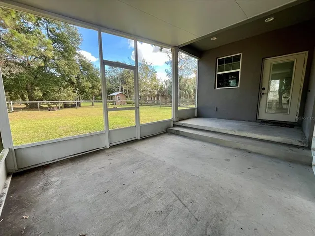 a view of an empty room with large windows