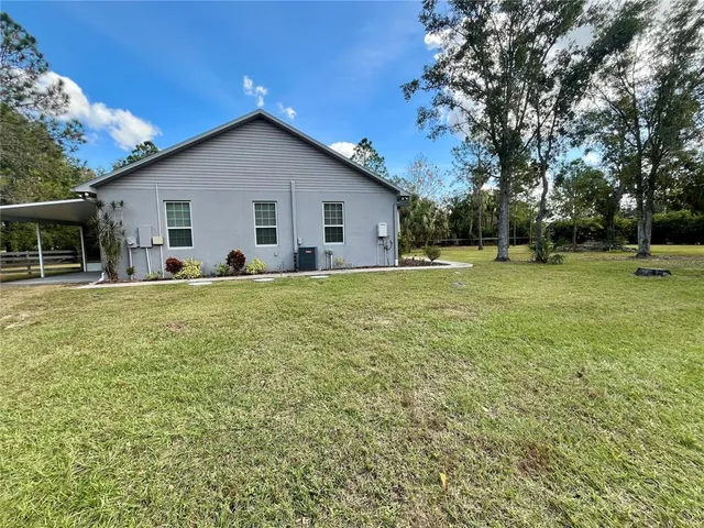 a view of a house with a yard and trees