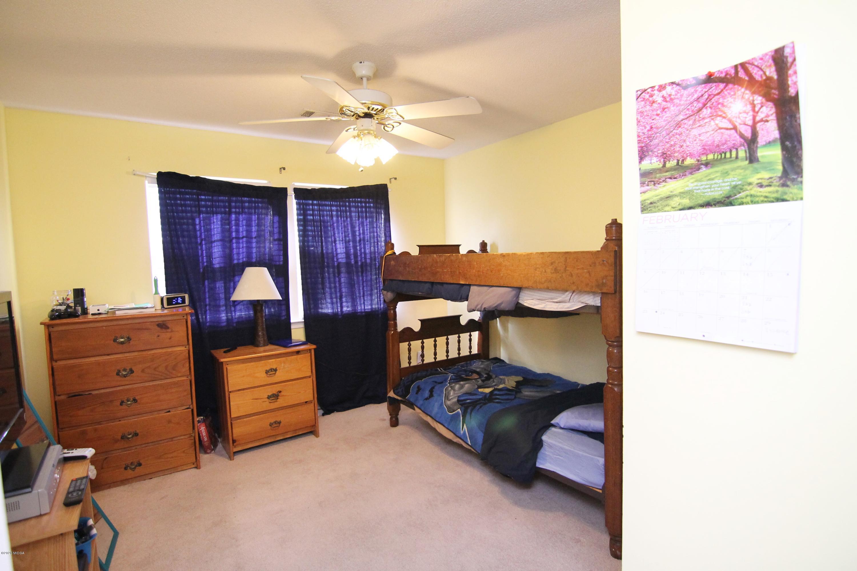 226 Ruben Road Byron, GA 31008 - Photo 22 of 30 a bedroom with a bed and a chandelier
