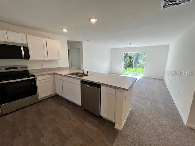 a kitchen with stainless steel appliances a sink stove and microwave