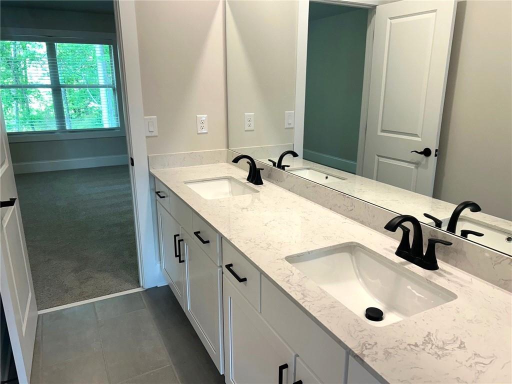 4265 Trinity Oaks Trail Cumming, GA 30040 - Photo 16 of 25 a bathroom with a double vanity sink a mirror and