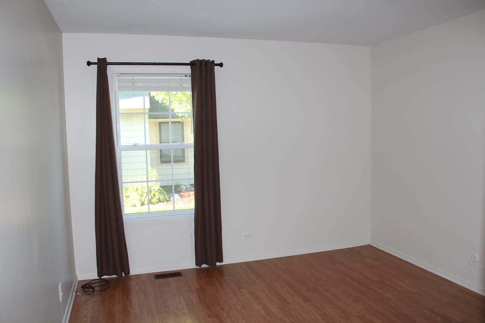 565 Dunham Road Gurnee, IL 60031 - Photo 6 of 17 a view of an empty room with wooden floor and a window