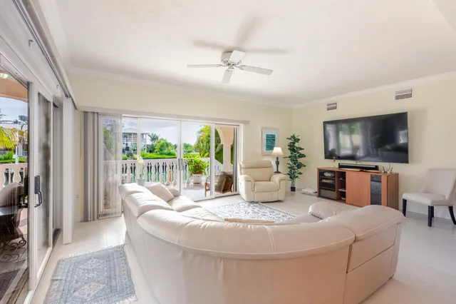 a kitchen with stainless steel appliances kitchen island granite countertop a refrigerator a sink dishwasher a dining table and chairs with wooden floor