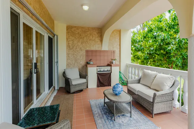 a living room with furniture a flat screen tv and a floor to ceiling window