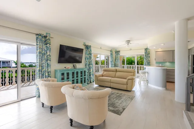a living room with furniture a flat screen tv and a floor to ceiling window