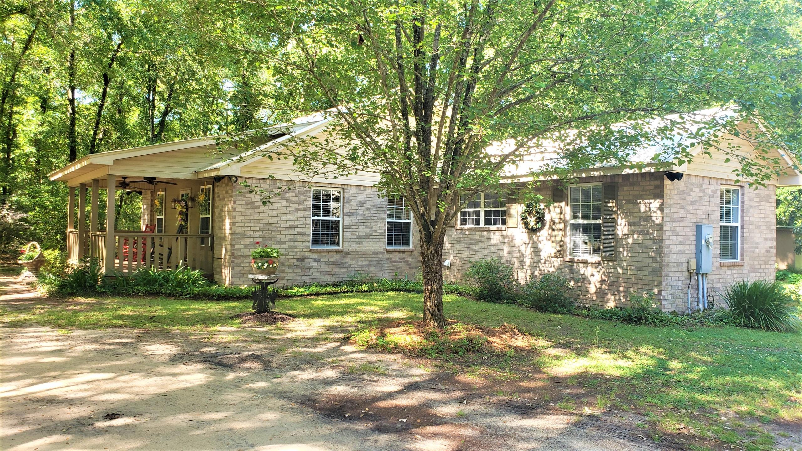 564 Harbuck Road DeFuniak Springs, FL 32433 - Photo 1 of 19 a view of a yard in front of a house with plants and large trees