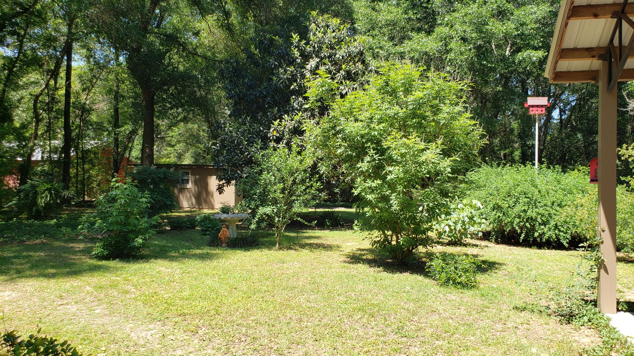 564 Harbuck Road DeFuniak Springs, FL 32433 - Photo 17 of 19 a view of a garden with plants and a bench