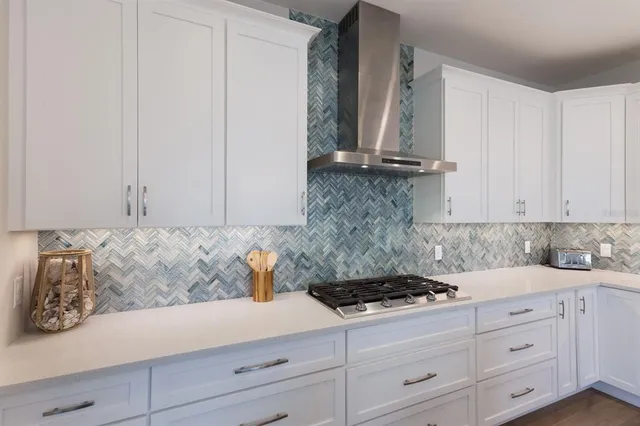 a kitchen with stainless steel appliances granite countertop a sink a stove and a wooden floors