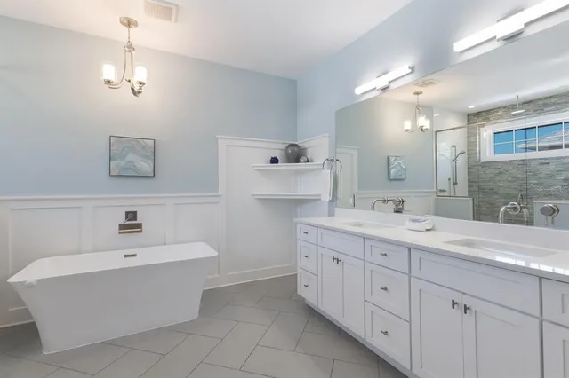 a bedroom with a large bed and two windows