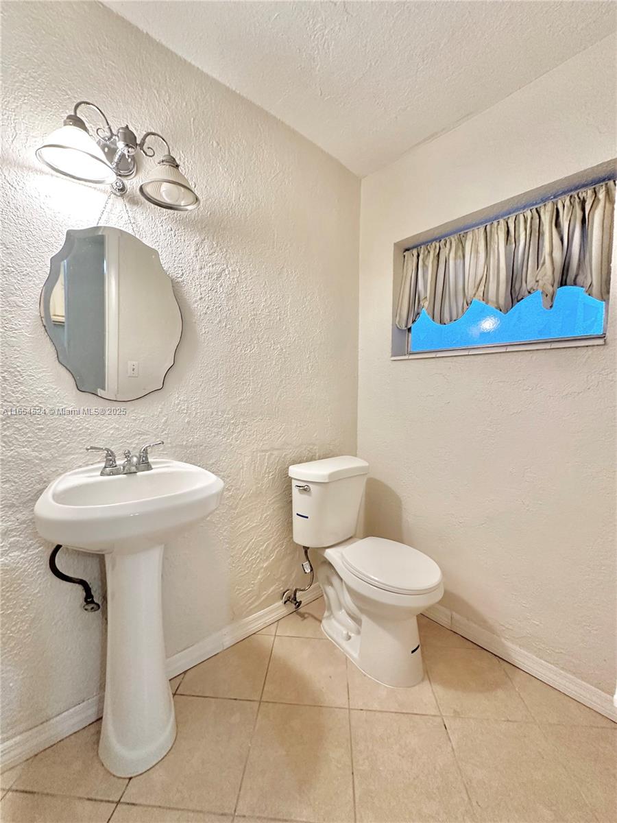 8650 Southwest 67th Avenue, Unit 1032 Pinecrest, FL 33156 - Photo 11 of 16 a bathroom with a toilet sink and mirror