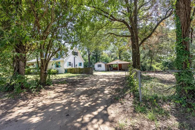 a backyard of a house with trees and outdoor seating