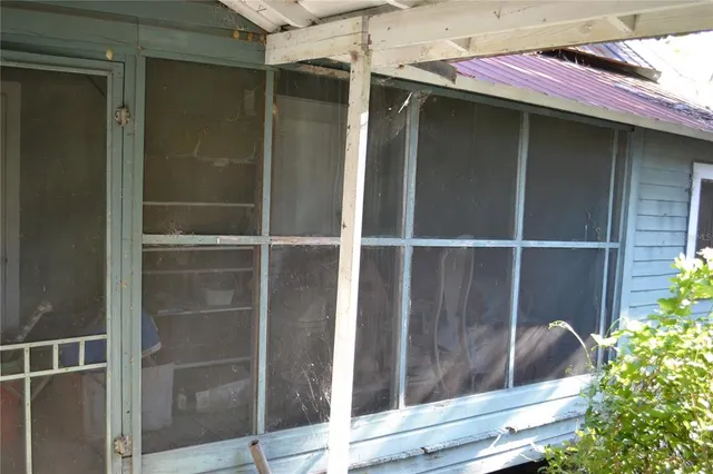 a view of a room with a large window and wooden floor