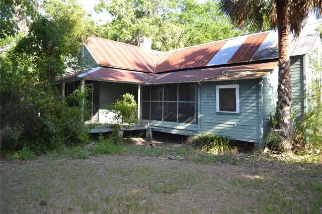 a view of a chair and table in backyard of the house