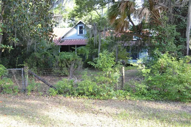 a front view of a house with a yard and fountain in middle