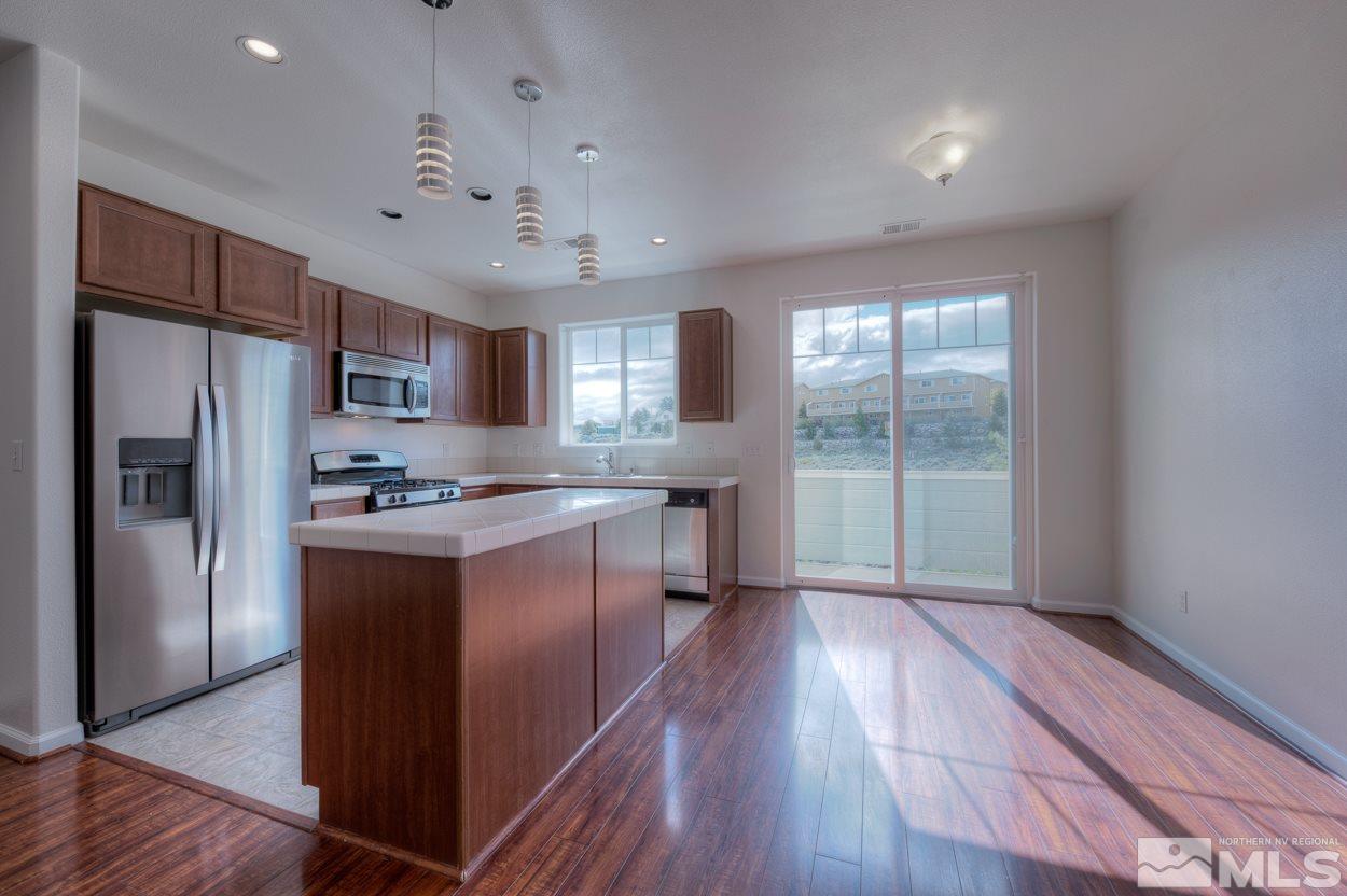 4800 Ciarra Kennedy Lane Reno, NV 89503 - Photo 8 of 25 a kitchen with stainless steel appliances granite countertop a refrigerator a sink dishwasher a stove and white countertops with wooden floor