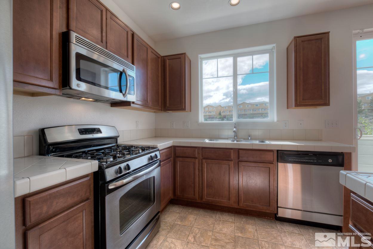 4800 Ciarra Kennedy Lane Reno, NV 89503 - Photo 10 of 25 a kitchen with granite countertop cabinets stainless steel appliances and a window