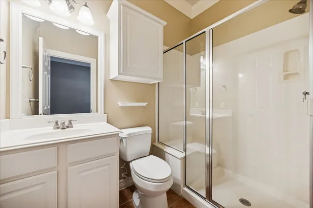 a bathroom with a toilet sink vanity and mirror